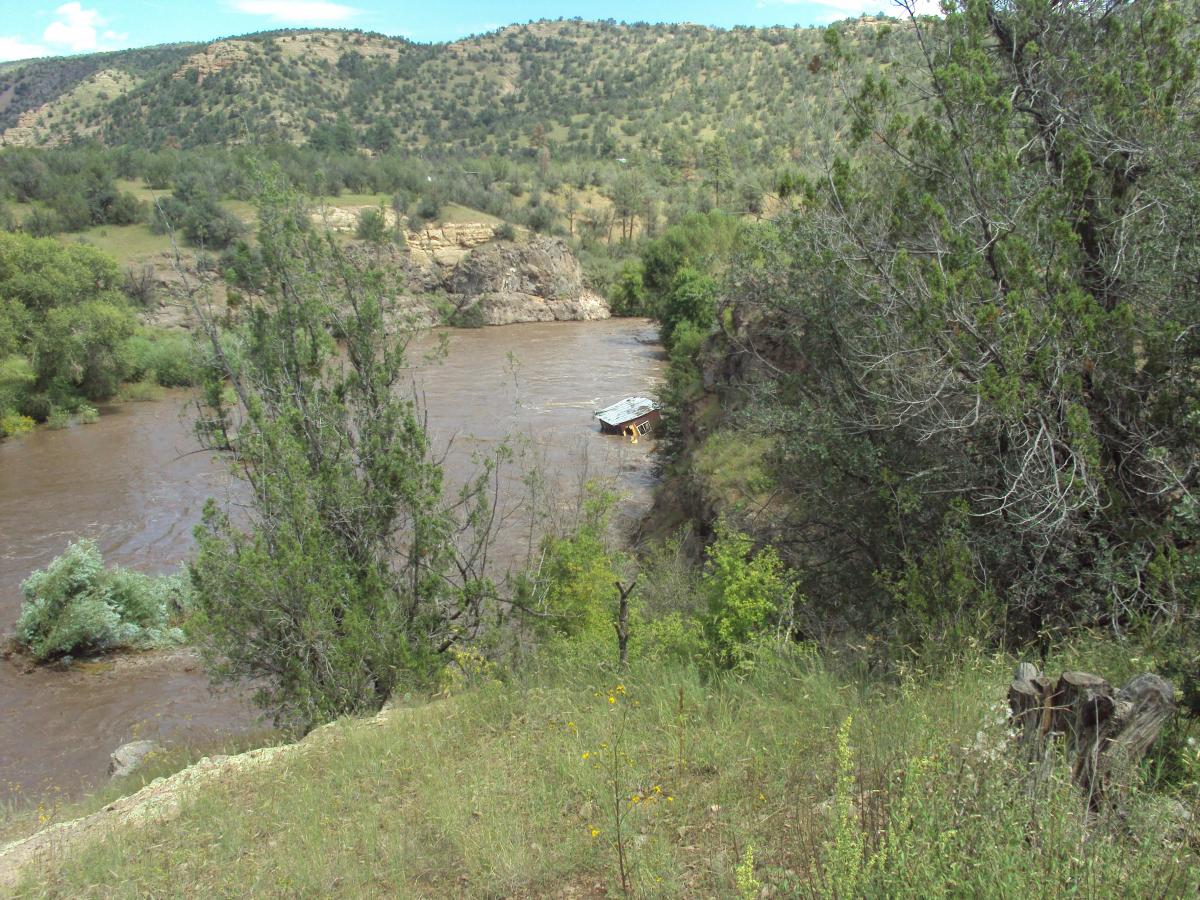Gila River in flood with shed floating away