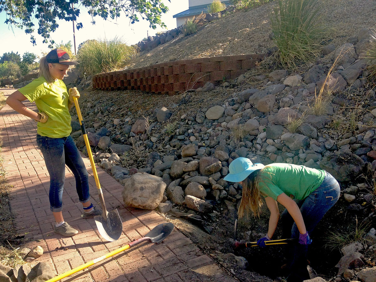 High school girls digging water harvesting basins