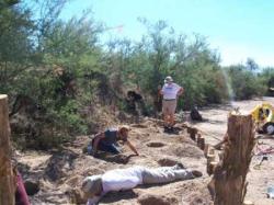 Photo by Chang You. Used with permission - Volunteers clean sand from the holes to prepare them for the juniper posts.